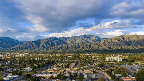 City neighborhood beneath dramatic sunlit mountain range
